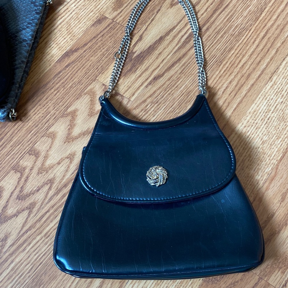 Black handbag with decorative gold snap closure.